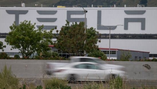 Vehicles pass the Tesla Inc. assembly plant in Fremont, California, U.S., on Monday, May 11, 2020. Elon Musk restarted production at Teslas only U.S. car plant, flouting county officials who ordered the company to stay closed and openly acknowledging he was risking arrest for himself and his employees.