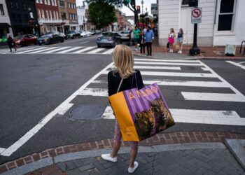 A shopper carries a bag in the Georgetown neighborhood of Washington, DC. Photographer: Al Drago/Bloomberg