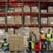 Workers apply labels to boxes. Photographer: Samuel Corum/Bloomberg