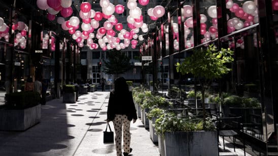 A pedestrian walks past storefronts at CityCenterDC in Washington, DC, US, on Thursday, May 30, 2024. The Bureau of Economic Analysis is scheduled to release personal consumption figures on May 31. Photographer: Bloomberg/Bloomberg