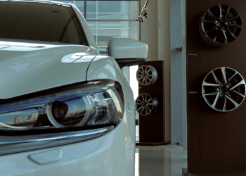car in dealership showroom next to wheel rims