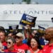 UAW members participate in a rally outside the Stellantis Sterling Heights Assembly Plant in Sterling Heights, Michigan, US, on Friday, Aug. 23, 2024. UAW members are participating in an informational rally after UAW locals representing tens of thousands of Stellantis workers filed grievances with the company over their failure to "Keep the Promise" made in contract negotiations in 2023, according to the organizers.