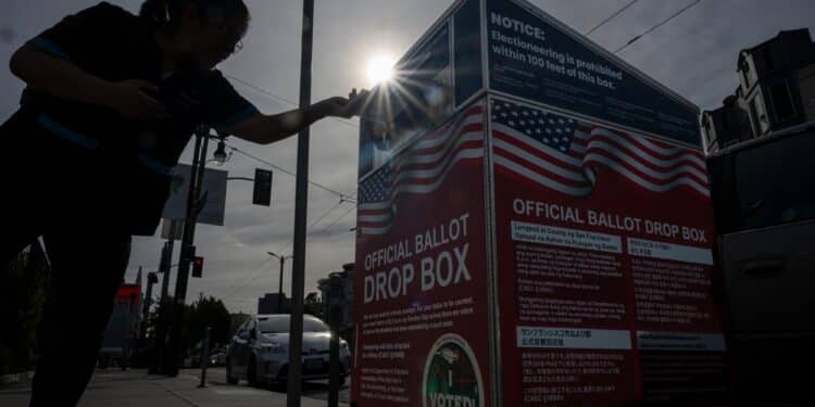 A voter submits their ballot at an official ballot drop box at a polling location for the 2024 Presidential election in San Francisco, California, US, on Tuesday, Nov. 5, 2024. The 2024 presidential campaign was marked by two assassination attempts, a candidate switch, divisive rhetoric and warnings about the fate of democracy. Photographer: David Paul Morris/Bloomberg
