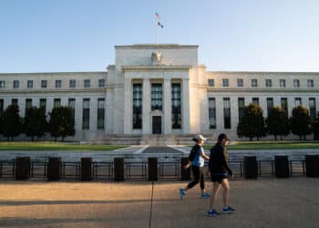 Joggers pass the U.S. Federal Reserve building in Washington, D.C., U.S., on Tuesday, August 18, 2020. Photographer: Erin Scott/Bloomberg