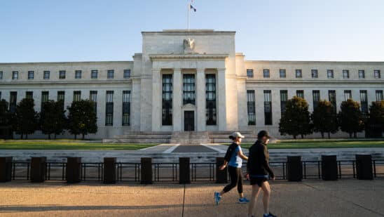 Joggers pass the U.S. Federal Reserve building in Washington, D.C., U.S., on Tuesday, August 18, 2020. Photographer: Erin Scott/Bloomberg
