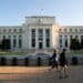 Joggers pass the U.S. Federal Reserve building in Washington, D.C., U.S., on Tuesday, August 18, 2020. Photographer: Erin Scott/Bloomberg