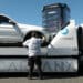 A worker unloads a vehicle from a flatbed truck at a Carvana vending machine location in Uniondale, New York, US, on Tuesday, April 16, 2024. Carvana Co. is scheduled to release earnings figures on May 1.