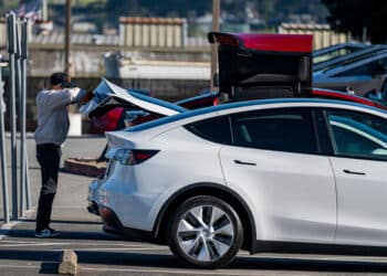A customer looks at the trunk of a vehicle at a Tesla store in Colma, California. Photographer: David Paul Morris/Bloomberg