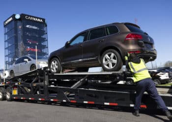 A worker loads vehicles onto a transporter at a Carvana vending machine location in Uniondale, New York, US, on Tuesday, April 16, 2024. Carvana Co. is scheduled to release earnings figures on May 1.