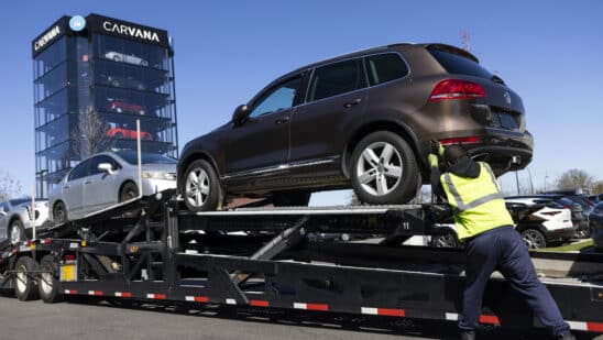 A worker loads vehicles onto a transporter at a Carvana vending machine location in Uniondale, New York, US, on Tuesday, April 16, 2024. Carvana Co. is scheduled to release earnings figures on May 1.