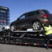 A worker loads vehicles onto a transporter at a Carvana vending machine location in Uniondale, New York, US, on Tuesday, April 16, 2024. Carvana Co. is scheduled to release earnings figures on May 1.