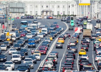 Lanes of a wide city street with lots of cars