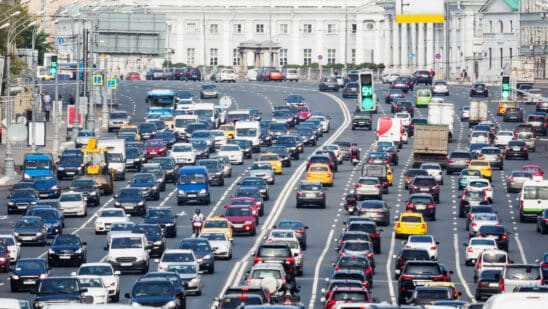 Lanes of a wide city street with lots of cars