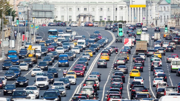 Lanes of a wide city street with lots of cars