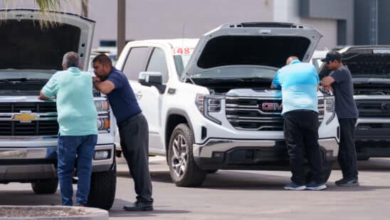 Customers look at vehicles for sale at a GMC Chevrolet dealership in Yuma, Arizona, US, on Monday, March 31, 2025. Whether Donald Trump's 25% tariffs on imported vehicles achieve the president's goal of revitalizing domestic auto manufacturing remains to be seen, but the levies that start April 3 are almost certain to push up the prices of new models if they stay in force for more than a few months.