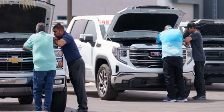 Customers look at vehicles for sale at a GMC Chevrolet dealership in Yuma, Arizona, US, on Monday, March 31, 2025. Whether Donald Trump's 25% tariffs on imported vehicles achieve the president's goal of revitalizing domestic auto manufacturing remains to be seen, but the levies that start April 3 are almost certain to push up the prices of new models if they stay in force for more than a few months.