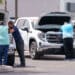 Customers look at vehicles for sale at a GMC Chevrolet dealership in Yuma, Arizona, US, on Monday, March 31, 2025. Whether Donald Trump's 25% tariffs on imported vehicles achieve the president's goal of revitalizing domestic auto manufacturing remains to be seen, but the levies that start April 3 are almost certain to push up the prices of new models if they stay in force for more than a few months. (Eric Thayer/Bloomberg)