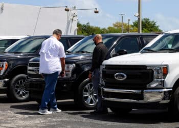 A customer views a new Ford Pro Super Duty pickup truck displayed for sale at a Ford Motor Co. dealership in Miami, Florida, US, on Saturday, April 5, 2025. Car buyers have been rushing to US showrooms to lock in deals before potential price hikes, and automakers are bracing for significant potential cost increases and supply-chain turmoil, with some companies planning to temporarily halt production or reduce overtime.