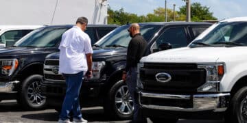 A customer views a new Ford Pro Super Duty pickup truck displayed for sale at a Ford Motor Co. dealership in Miami, Florida, US, on Saturday, April 5, 2025. Car buyers have been rushing to US showrooms to lock in deals before potential price hikes, and automakers are bracing for significant potential cost increases and supply-chain turmoil, with some companies planning to temporarily halt production or reduce overtime.