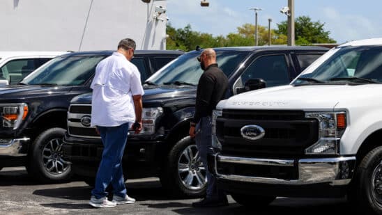 A customer views a new Ford Pro Super Duty pickup truck displayed for sale at a Ford Motor Co. dealership in Miami, Florida, US, on Saturday, April 5, 2025. Car buyers have been rushing to US showrooms to lock in deals before potential price hikes, and automakers are bracing for significant potential cost increases and supply-chain turmoil, with some companies planning to temporarily halt production or reduce overtime.