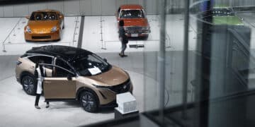 A Nissan Motor Co. Ariya electric crossover sport utility vehicle (SUV), bottom, on display in a showroom at the company's global headquarters in Yokohama, Japan, on Wednesday, Nov. 9, 2022. Nissan raised its profit outlook as a weak yen boosted repatriated income, helping to compensate for a persistent shortage of chips and supply-chain constraints that have curtailed output in the industry.