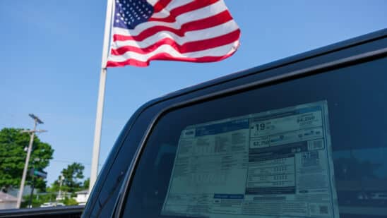 american flag by car as tariffs raise prices