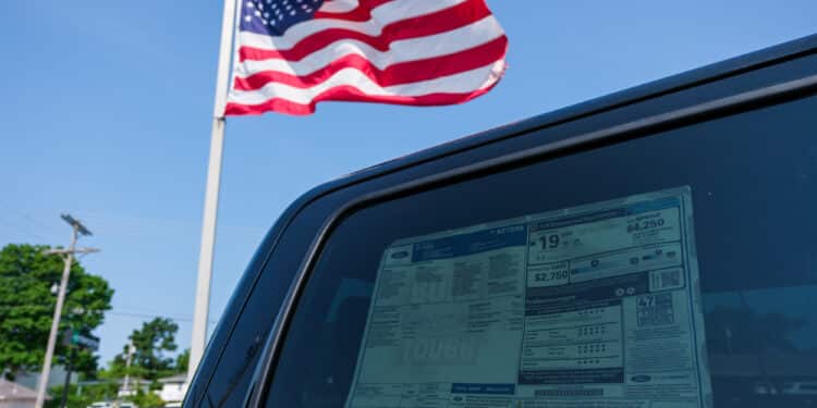 american flag by car as tariffs raise prices