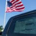 american flag by car as tariffs raise prices