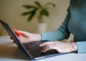 A woman uses a laptop whilst holding a debit card in this arranged photograph in London, United Kingdom, on Thursday, September 10, 2020. Photographer: Hollie Adams/Bloomberg