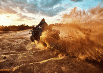 someone riding quad bike on dirt