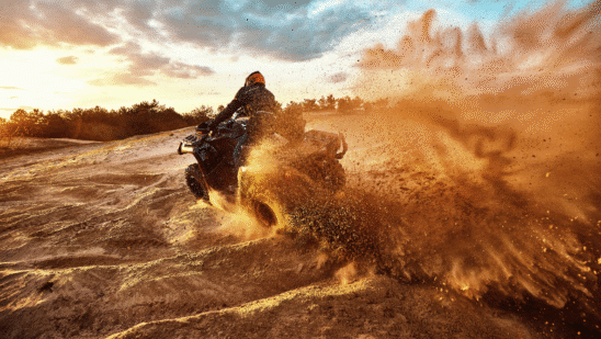 someone riding quad bike on dirt