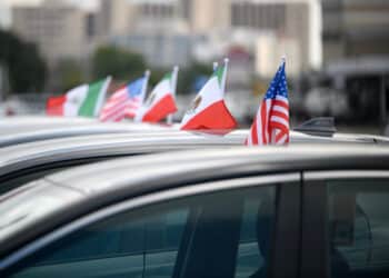 Mexican and American flags attached to vehicles at a Tricolor dealership in Houston.