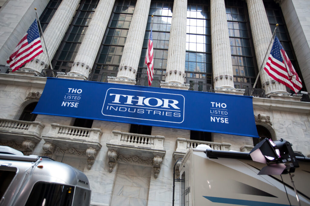Thor Industries Inc. signage hangs below American flags outside the New York Stock Exchange (NYSE) in New York, U.S., on Monday, Aug. 29, 2016. U.S. stocks rose, halting the longest slide since June, as an increase in consumer spending last month bolstered confidence in the economy and a drop in Treasury yields sparked demand for equities with rates of dividend payouts.