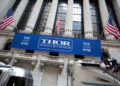 Thor Industries Inc. signage hangs below American flags outside the New York Stock Exchange (NYSE) in New York, U.S., on Monday, Aug. 29, 2016. U.S. stocks rose, halting the longest slide since June, as an increase in consumer spending last month bolstered confidence in the economy and a drop in Treasury yields sparked demand for equities with rates of dividend payouts.
