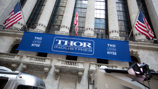 Thor Industries Inc. signage hangs below American flags outside the New York Stock Exchange (NYSE) in New York, U.S., on Monday, Aug. 29, 2016. U.S. stocks rose, halting the longest slide since June, as an increase in consumer spending last month bolstered confidence in the economy and a drop in Treasury yields sparked demand for equities with rates of dividend payouts.