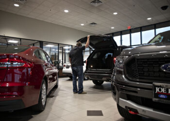 A customer looks over an SUV at a car dealership in Orland Park, Illinois.
