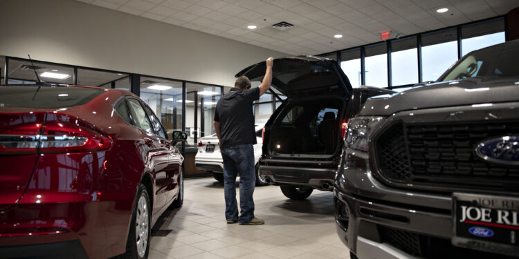 A customer looks over an SUV at a car dealership in Orland Park, Illinois.