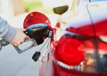 close up of red car and person pumping gas