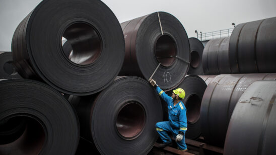 A worker inspects coils of steel in the storage yard at a steel plant in Ostrava, Czech Republic.