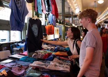 A customer looks at clothing for sale at the Pike Place Market in Seattle.