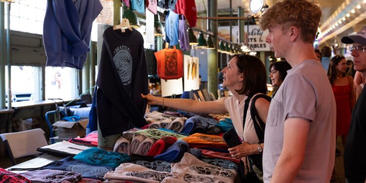 A customer looks at clothing for sale at the Pike Place Market in Seattle.