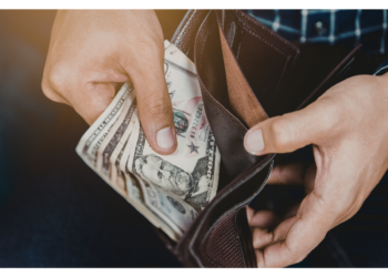 A person removes U.S. currency from a wallet.
