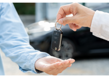 A person hands a car key fob to another person.
