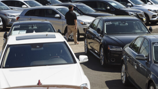 A car dealer walks past cars for sale at a used car dealership in Jersey City, New Jersey, U.S, on Wednesday, May 20, 2020. Governor Phil Murphy has lifted restrictions on in-person auto sales, provided the businesses follow social distancing guidelines, NBC reported.