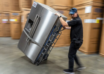 A worker moves a refrigerator at an appliance store in Santa Clara, California. Photographer: David Paul Morris/Bloomberg