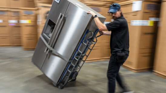 A worker moves a refrigerator at an appliance store in Santa Clara, California. Photographer: David Paul Morris/Bloomberg