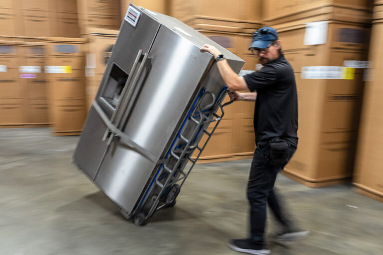 A worker moves a refrigerator at an appliance store in Santa Clara, California. Photographer: David Paul Morris/Bloomberg
